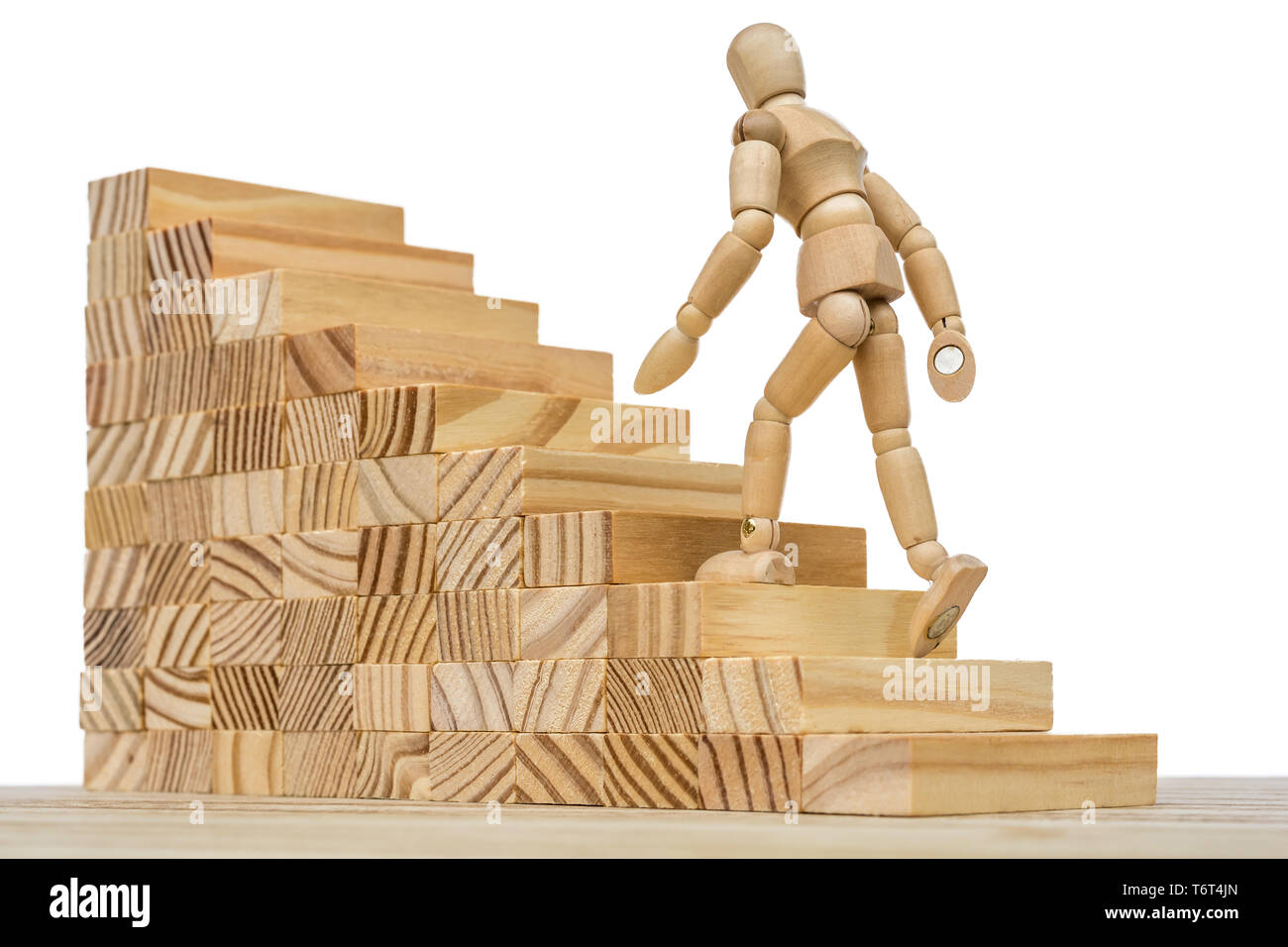 Holzfigur läuft bis hohe Treppe als Metapher für Job und Karriere Stockfoto