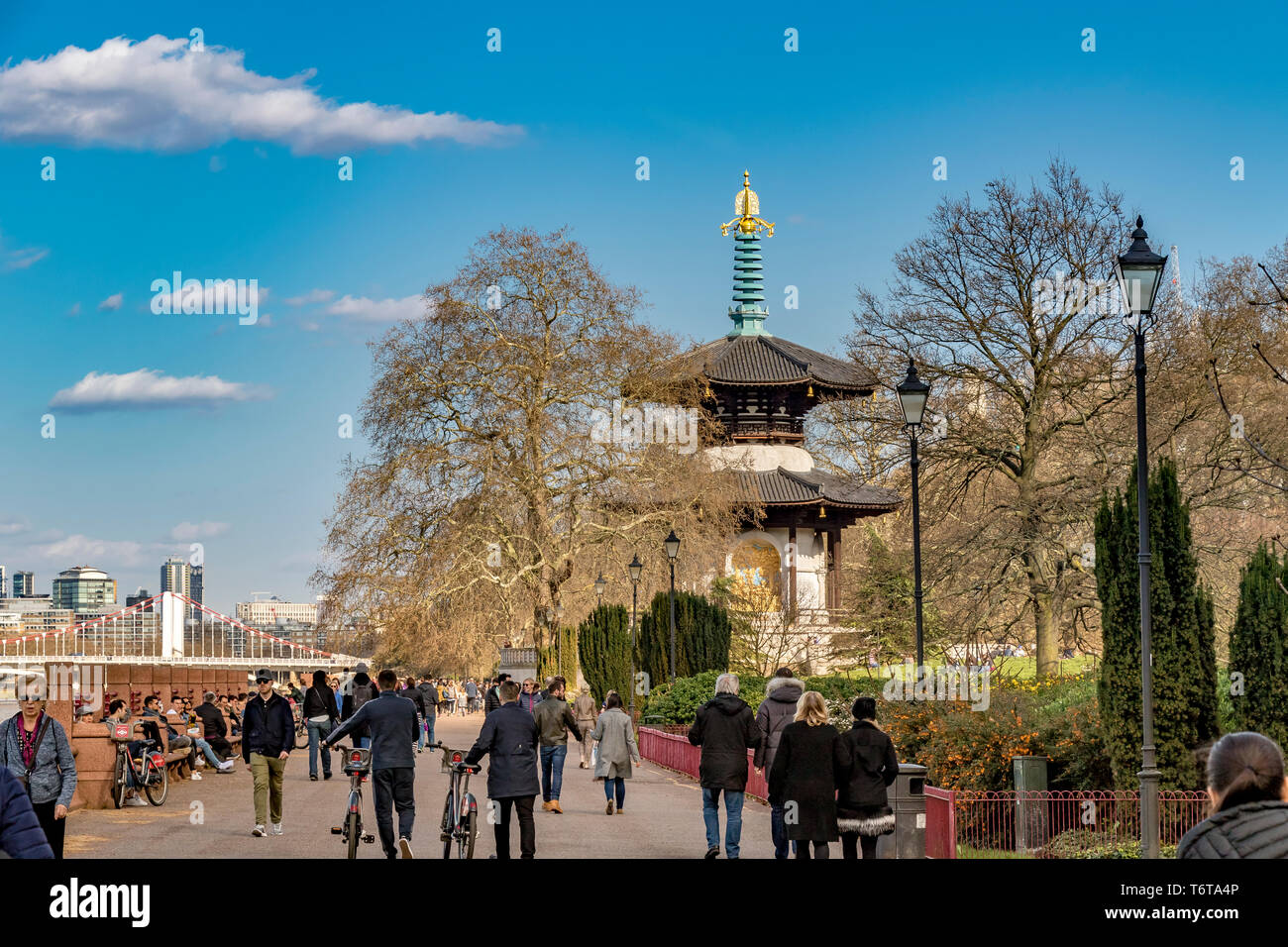 Menschen, die an einem schönen Frühlingstag in Battersea, London, Großbritannien, durch den Battersea Park in der Nähe der Londoner Friedenspagode schlendern Stockfoto
