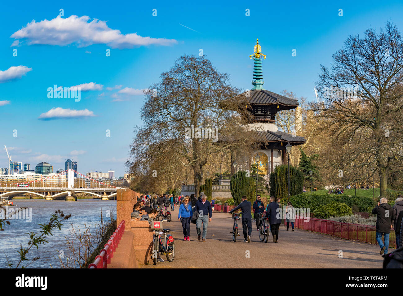 Menschen, die an einem schönen Frühlingstag in London, Battersea, London, Großbritannien, durch den Battersea Park in der Nähe der Londoner Friedenspagode schlendern Stockfoto