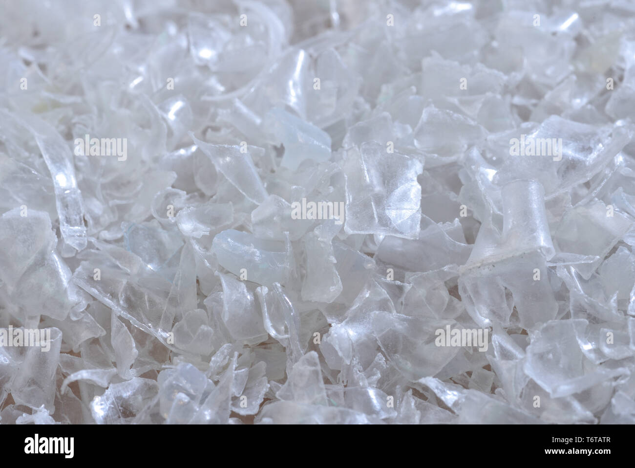 Flocken der zerquetschten Plastikflaschen als Rohstoff für die weitere Verarbeitung. Stockfoto