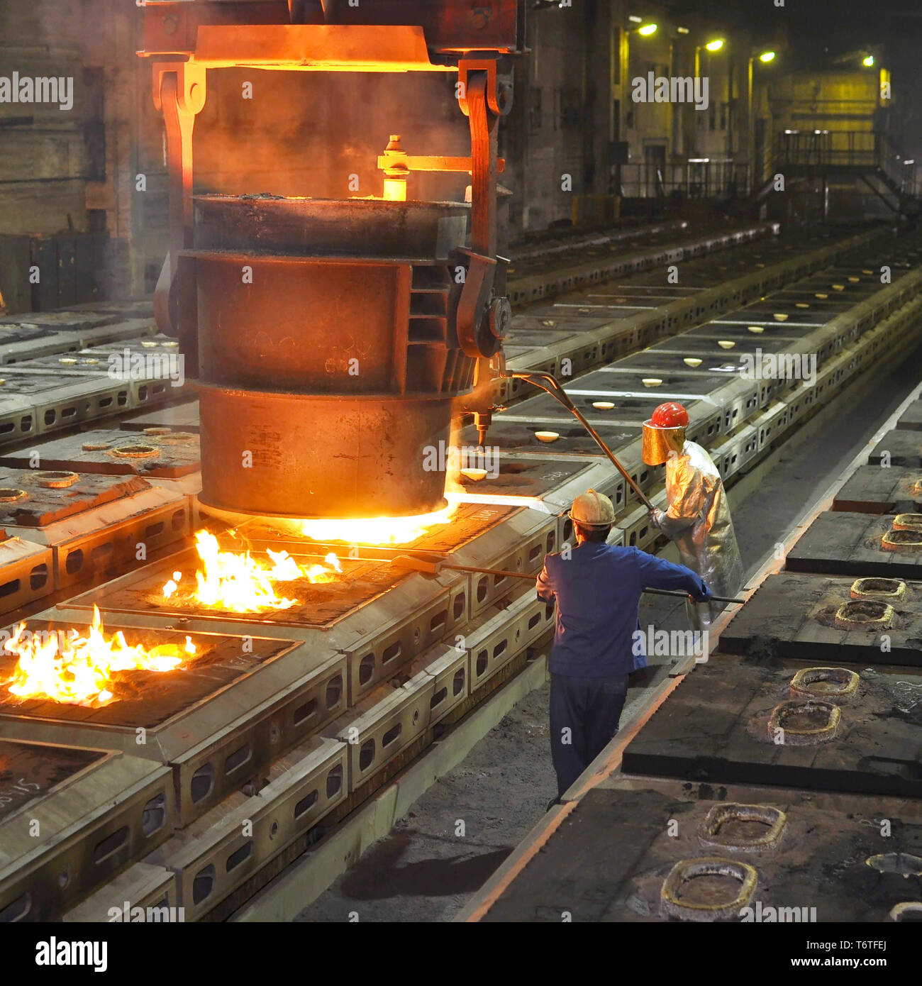 Produktion von Metallkomponenten in einer Gießerei - Gruppe der Arbeitnehmer Stockfoto