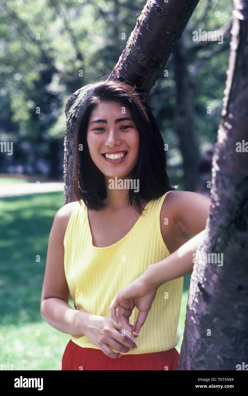 1987 historische junge asiatische Frau IM PARK TRAGEN ÜBUNG OUTFIT Stockfoto