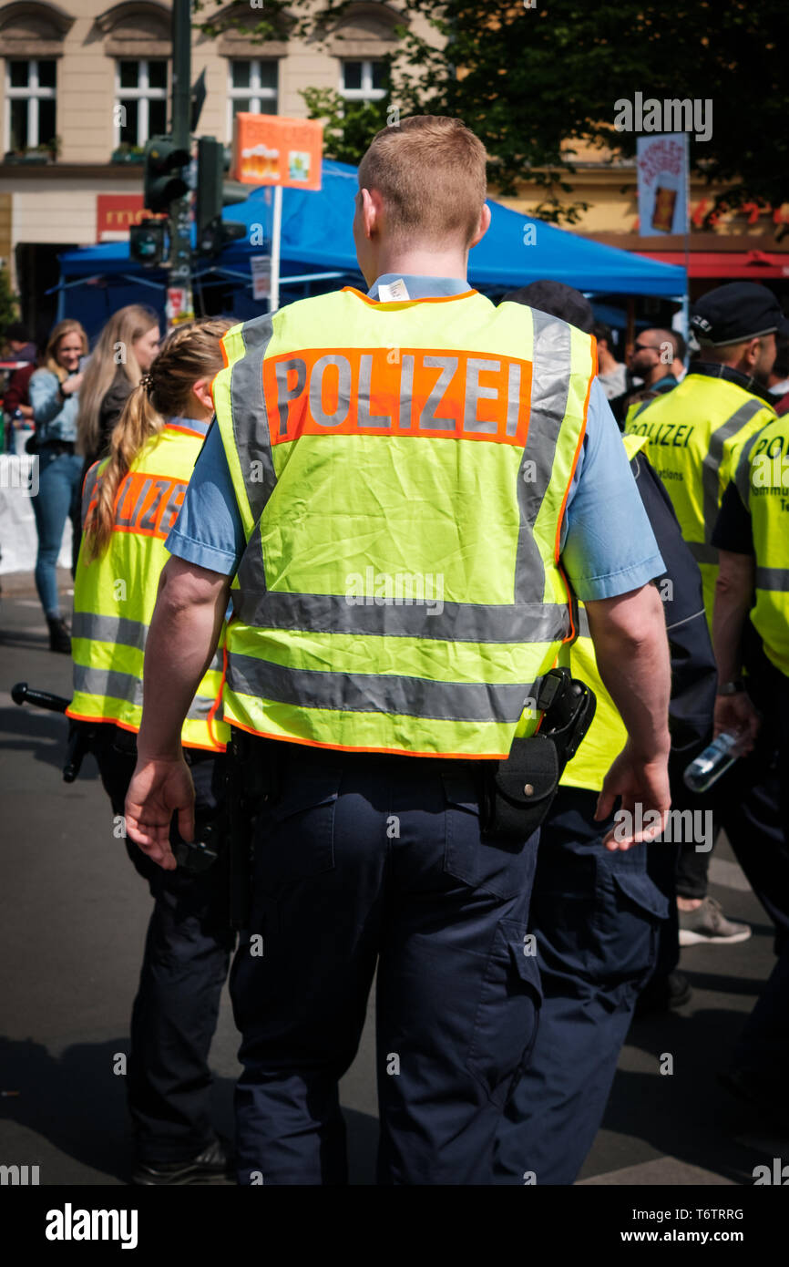 Berlin, Deutschland - 01.Mai 2019: Deutsche Polizei von hinten in überfüllten Street Parade am Tag der Arbeit in Berlin. Stockfoto