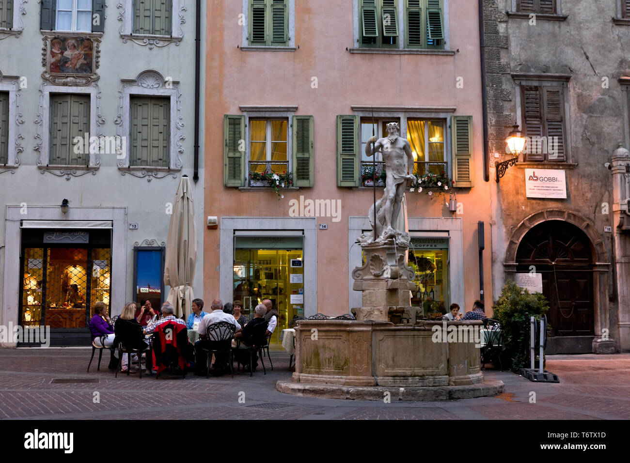 Rovereto: veduta serale di Piazza Cesare Battisti (ex-Piazza delle Oche) con La Fontana del Nettuno. Gente al tavolino di un-bar. [ENG] Rovereto: Ev Stockfoto