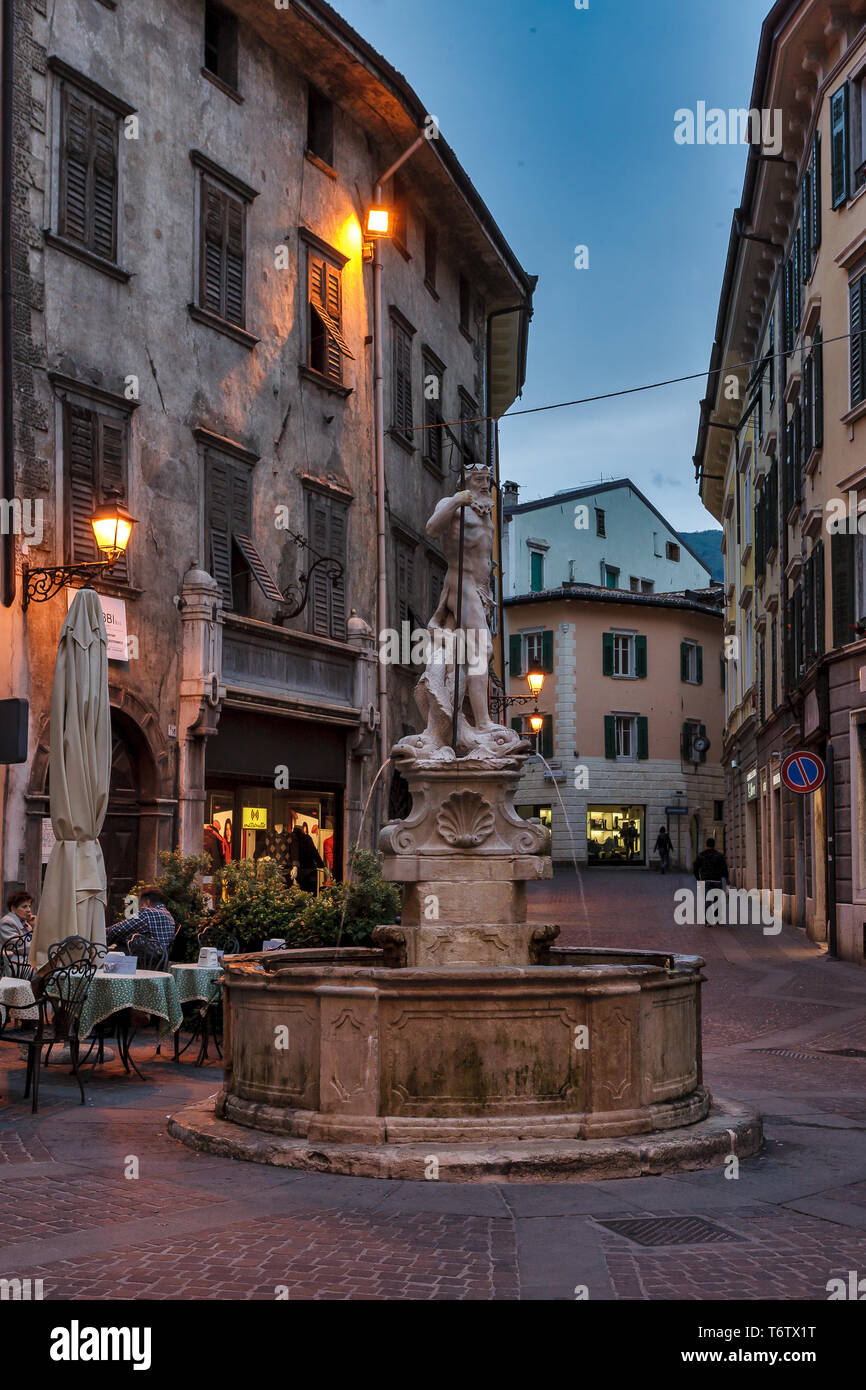 Rovereto: veduta serale di Piazza Cesare Battisti (ex-Piazza delle Oche) con La Fontana del Nettuno. Gente al tavolino di un bar [ENG] Rovereto: Eve Stockfoto
