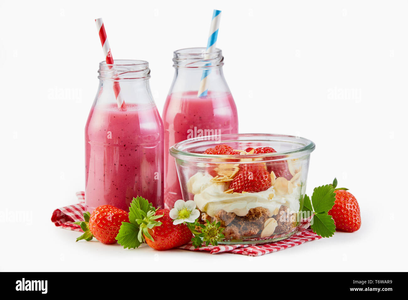 Erdbeere Smoothies mit Müsli und Joghurt mit frischem Obst und Nüsse für ein gesundes Frühstück über Weiß Stockfoto