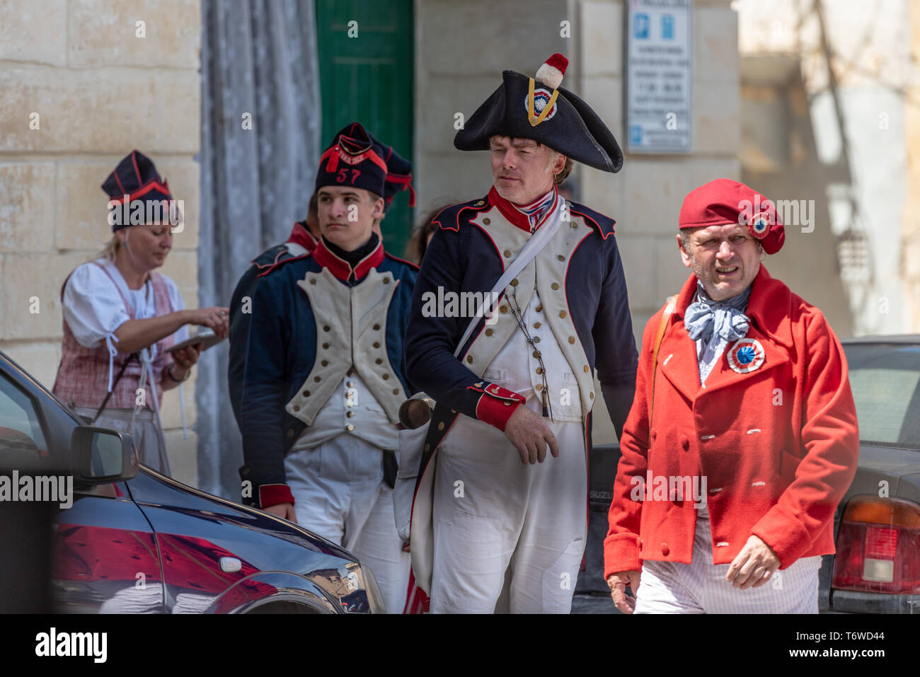 Liebhaber historischer Nachstellungen in napoleonischen Rumpfuniformen und Bicorn-Hüten erkunden die historischen Straßen von Il-Birgu auf Malta Stockfoto