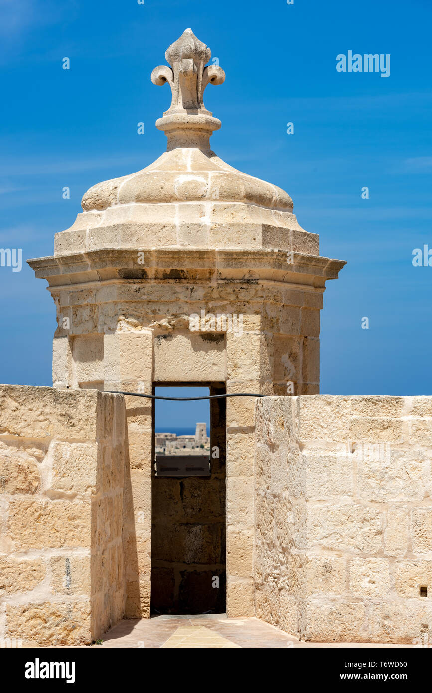Eine Gardjola-Wache aus Kalkstein in Fort St Angelo auf Malta mit einem kunstvoll geschnitzten Fleur-de-Lis auf dem Dach Stockfoto