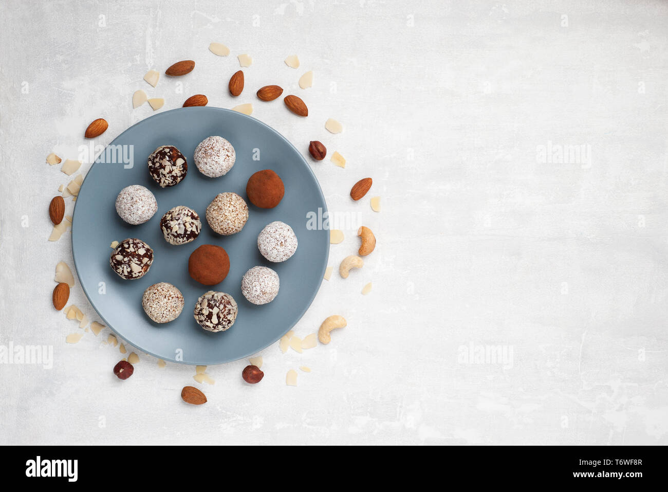 Gesunde organische Energie beißt mit Nüssen, Chia Samen, Mandeln, Kokos cheeps und getrocknete Früchte, rohes Dessert Snacks auf einem Tisch vegan. Flach. Stockfoto