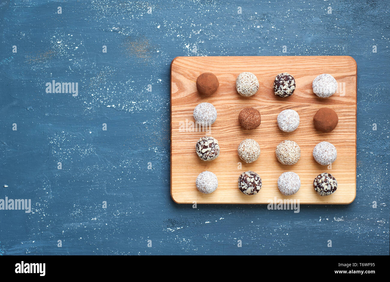 Gesunde Rohstoffe Energie Kugeln mit Kakao, Kokosnuss, Sesam und Früchten zubereitet. Vegane Schokolade Trüffel. Flach mit kopieren. Stockfoto