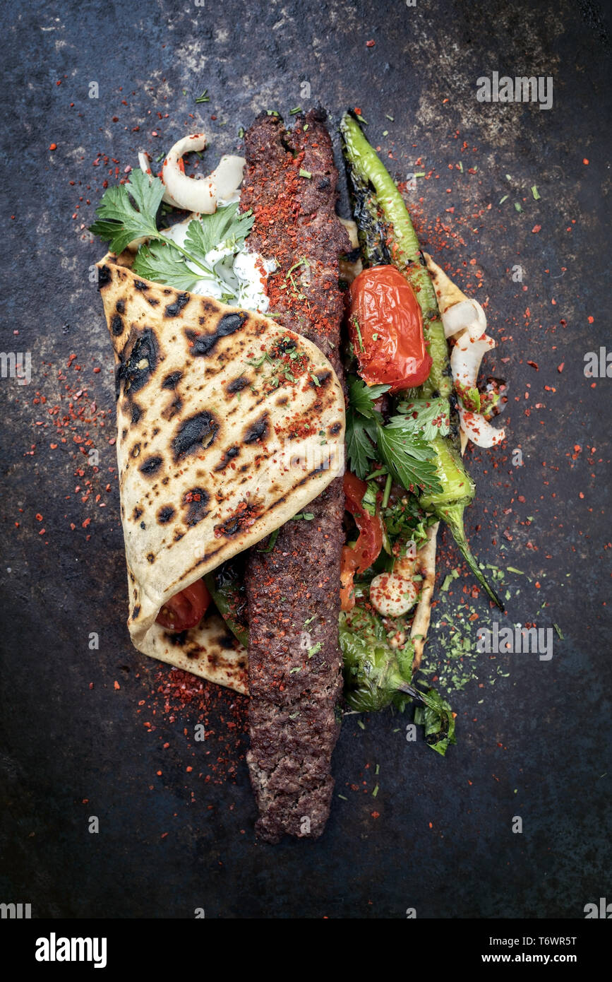 Traditionelle Adana Kebap mit Tomaten und Joghurt auf einem fladenbrot ...