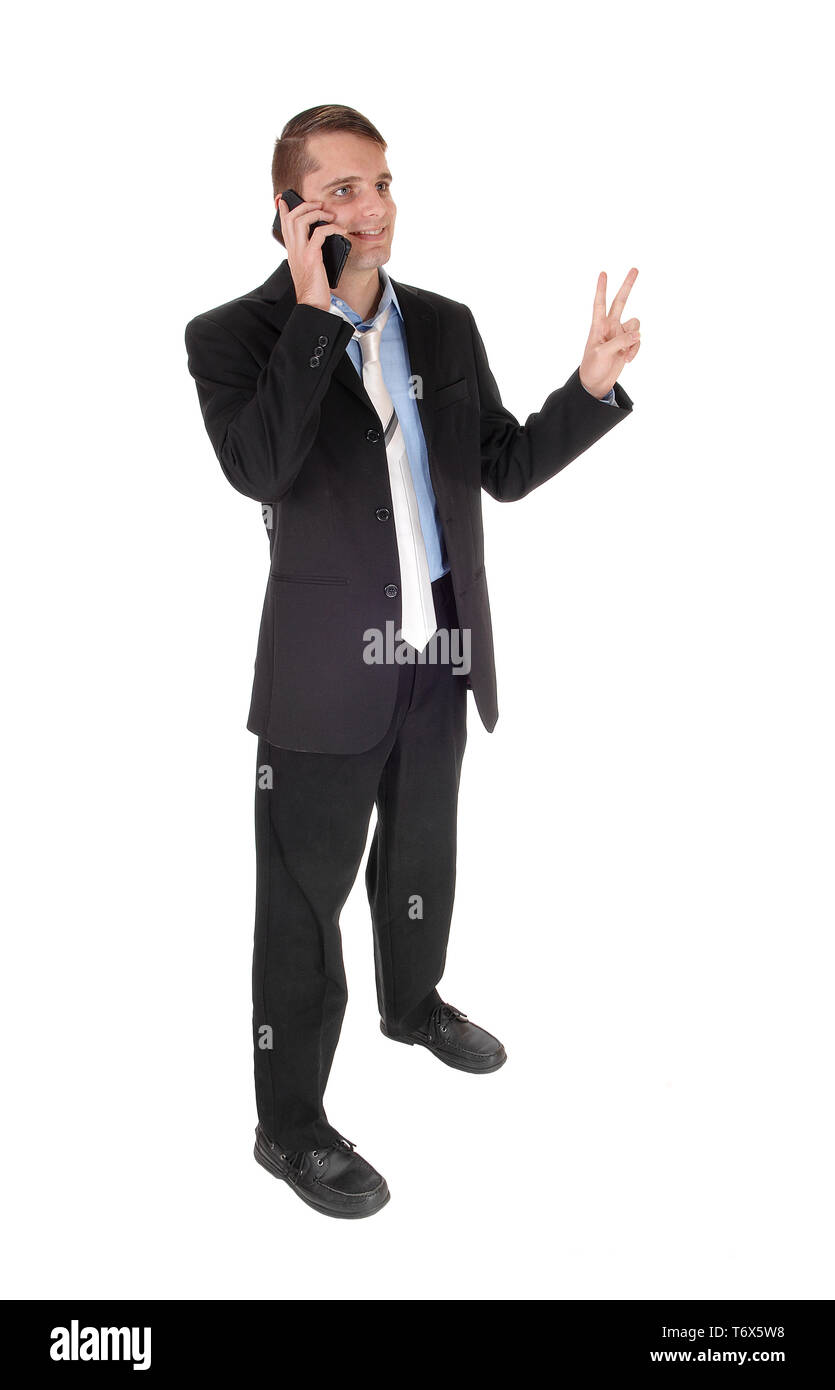 Mann am Telefon sprechen mit Sieg Zeichen Stockfoto