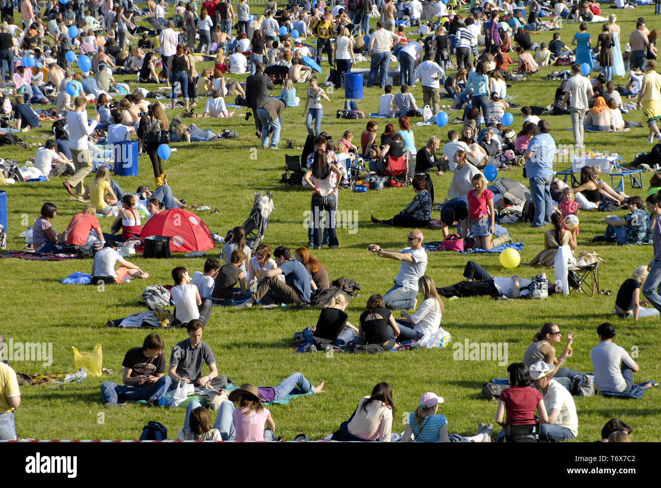 Viele Menschen die Zeit auf grünem Gras an Outdoor Event Stockfoto