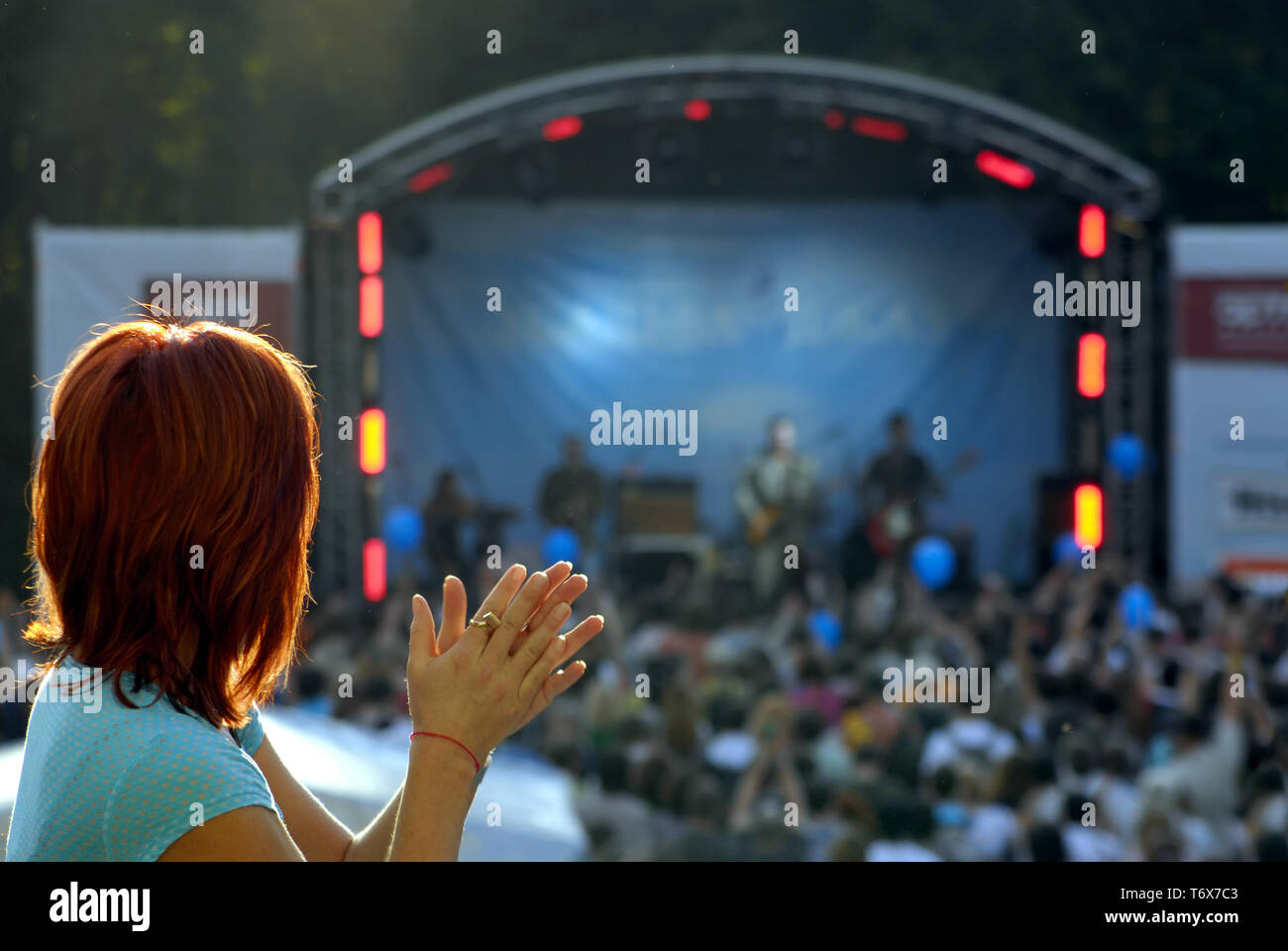 Junge Frau applaudiert. Konzert auf der Open Air Bühne Stockfoto
