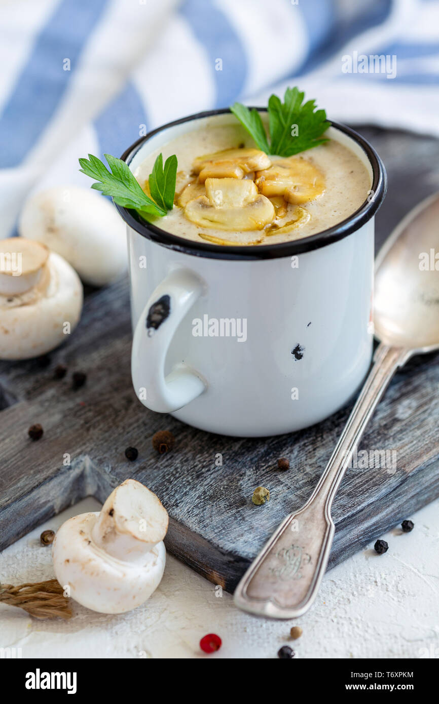 Creme - Suppe mit Champignons in einem Emaille Tasse. Stockfoto