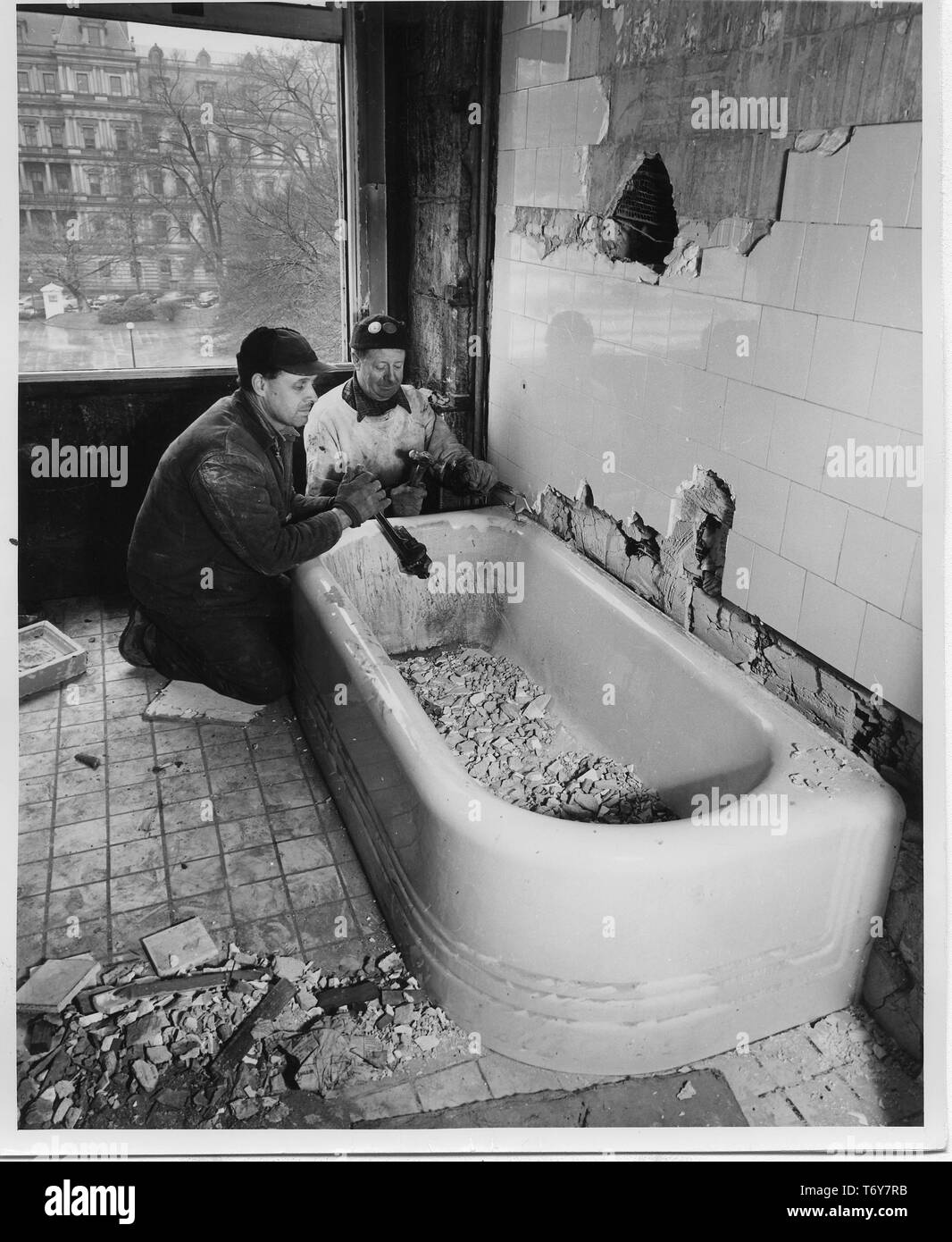 Zwei Arbeiter eine Badewanne, in der nordwestlichen Ecke Zimmer auf der zweiten Etage das Weiße Haus demontieren, während Präsident Truman's White House Wiederaufbau, Washington, District of Columbia, 10. Februar 1950. Mit freundlicher Genehmigung der nationalen Archive. () Stockfoto