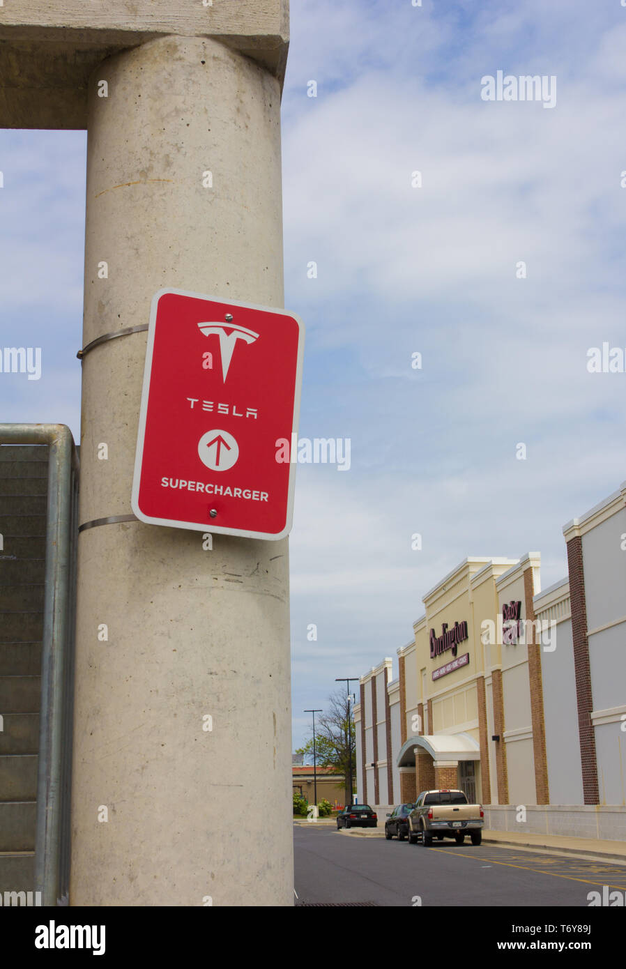 Im Mai 2019 wurde angekündigt, dass Tesla, Inc. co-Gründer/CEO Elon Musk war einer der Gewinner des 2019 Stephen Hawking Medaille für Wissenschaftskommunikation. Dargestellt im April 2019, in vertikaler Ausrichtung und mit verschiedenen Geschäften im Hintergrund Towne Center am Lorbeer Einkaufszentrum/Mitte in Laurel, Maryland, USA, ein rotes 'Tesla Kompressor' Schild mit Logo auf einem der Pfeiler der Tiefgarage/Parkhaus, wo Ladestationen für die Kalifornien zur Verfügung stehen - die Basis Automotive Company Elektrofahrzeuge. Mai 2019, Tesla hatte mehr als 1.440 Kompressor Stationen weltweit. Stockfoto