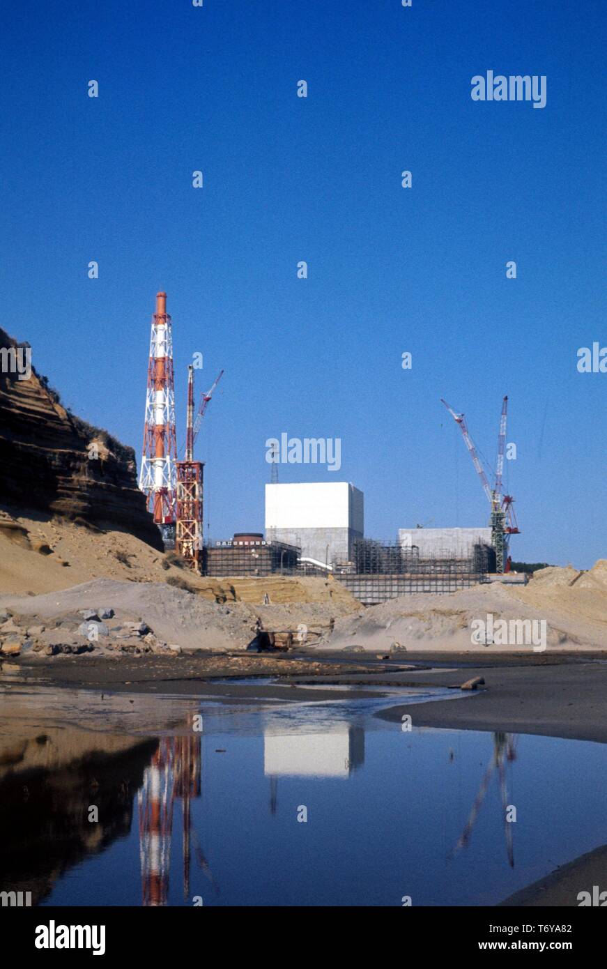 Fukushima Daiichi, im Bau an einem sonnigen Tag, in einem Pool von Wasser durch Sand im Vordergrund schneiden, Fukushima, Japan, 1970 wider. Mit freundlicher Genehmigung des US-Ministeriums für Energie. () Stockfoto