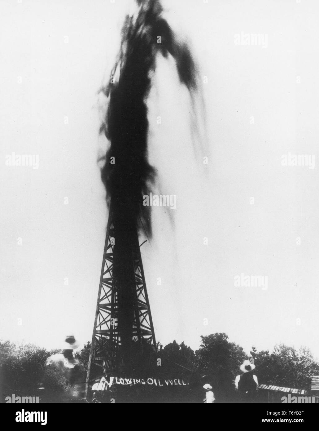 Mehrere Personen, von der Rückseite, beobachten Sie eine Feder der Ölstand über der Oberseite eines Derrick, 1919 sprudeln. Mit freundlicher Genehmigung des US-Ministeriums für Energie, Oklahoma. () Stockfoto