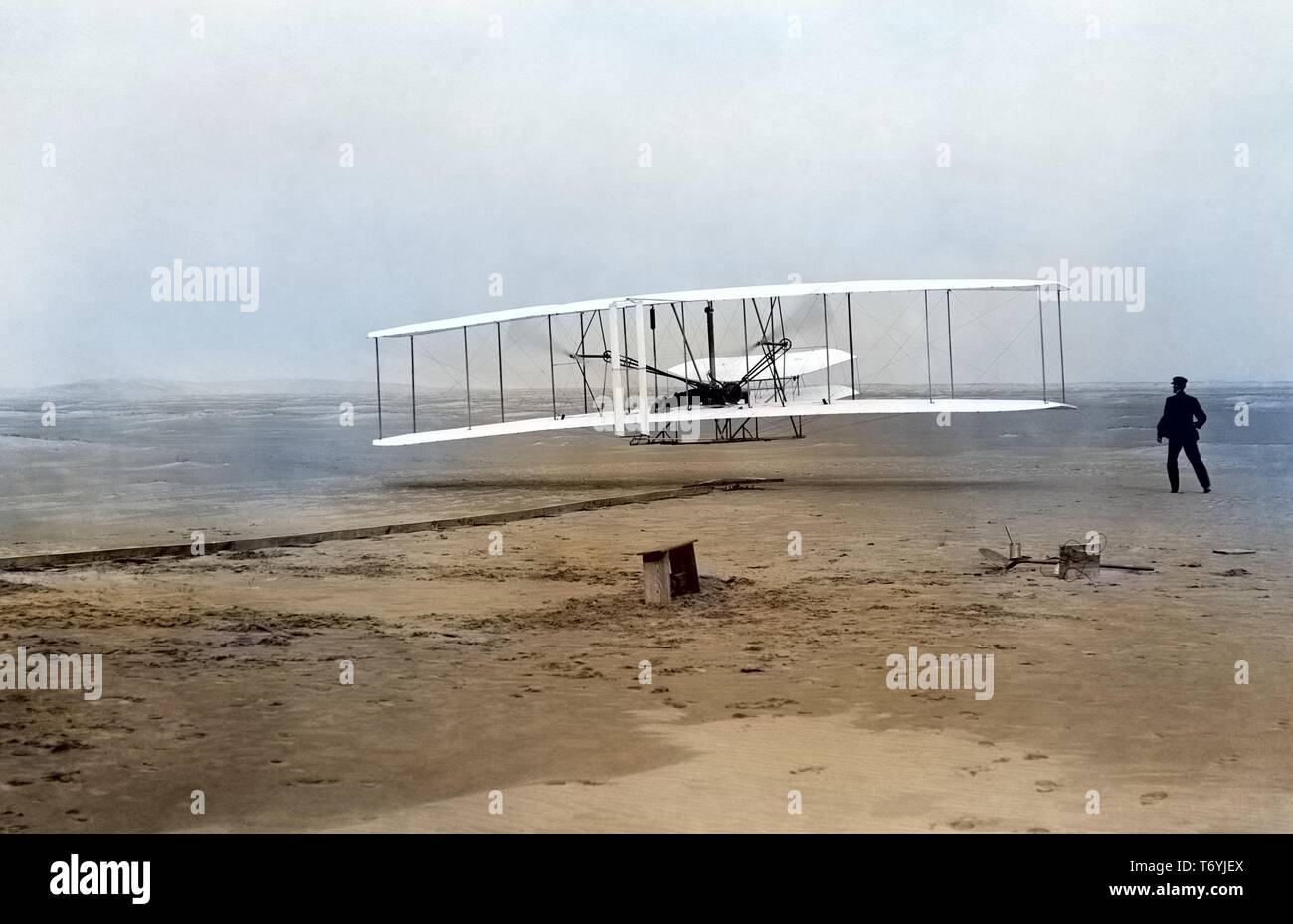 Foto von Orville Wright Pilotierung der historischen ersten angetriebenen Flugzeug, während sein Bruder Wilbur der Flug beobachtet, in Kitty Hawk, North Carolina, 17. Dezember 1903. Hinweis: Das Bild wurde mit einem modernen digitalen Prozess eingefärbt worden; Farben möglicherweise nicht sein - genau. () Stockfoto