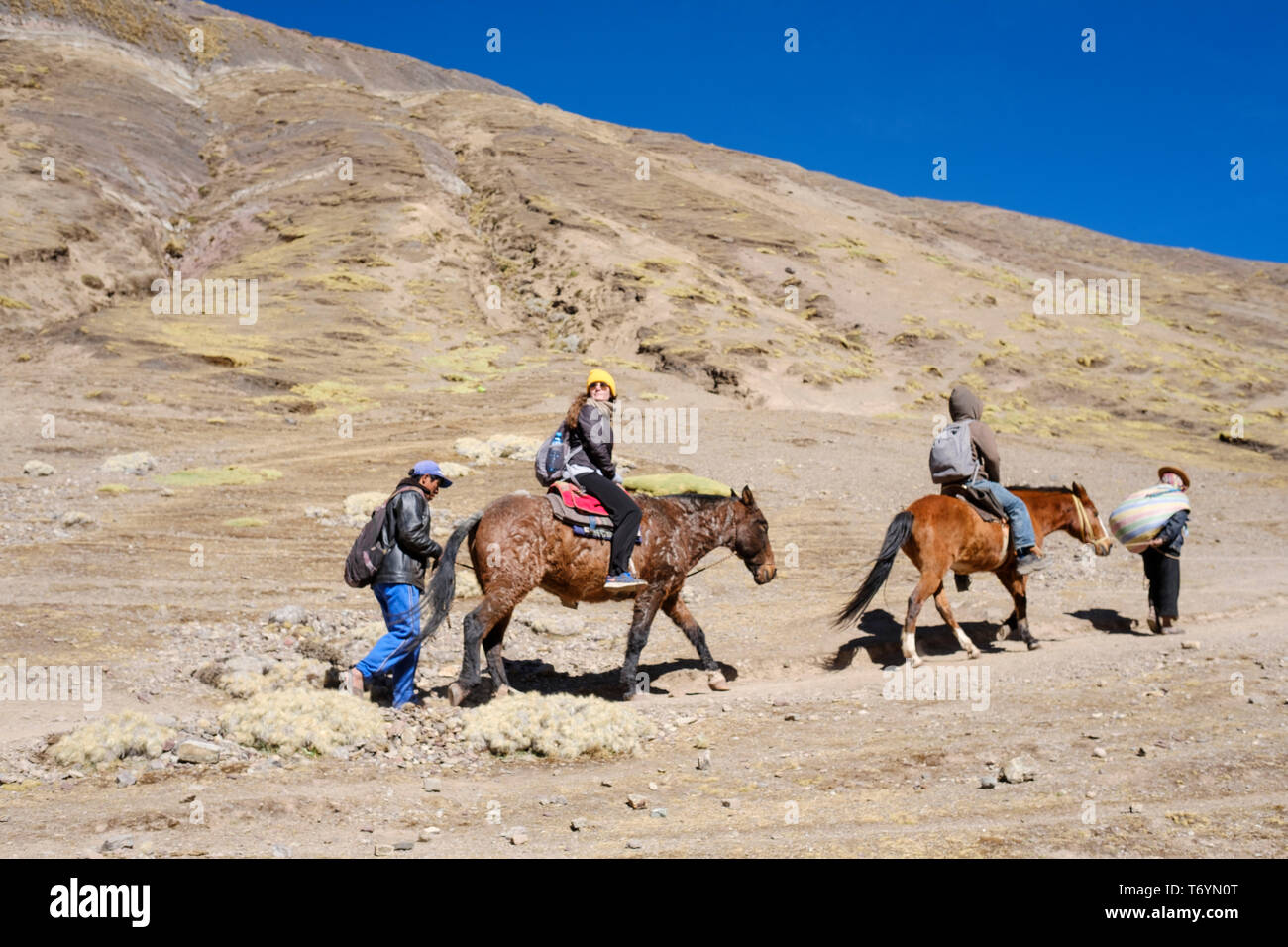 Touristen ein Pferd reiten zu den eindrucksvollen Rainbow Berg in Los Andes von Peru zu erhalten Stockfoto