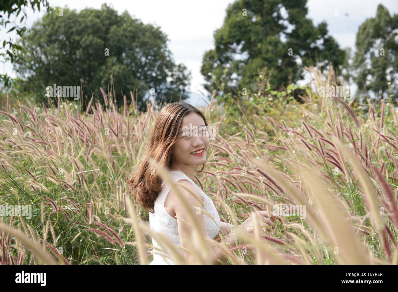 Portrait Foto von einem Mädchen lächelnd neben der Blumen Stockfoto