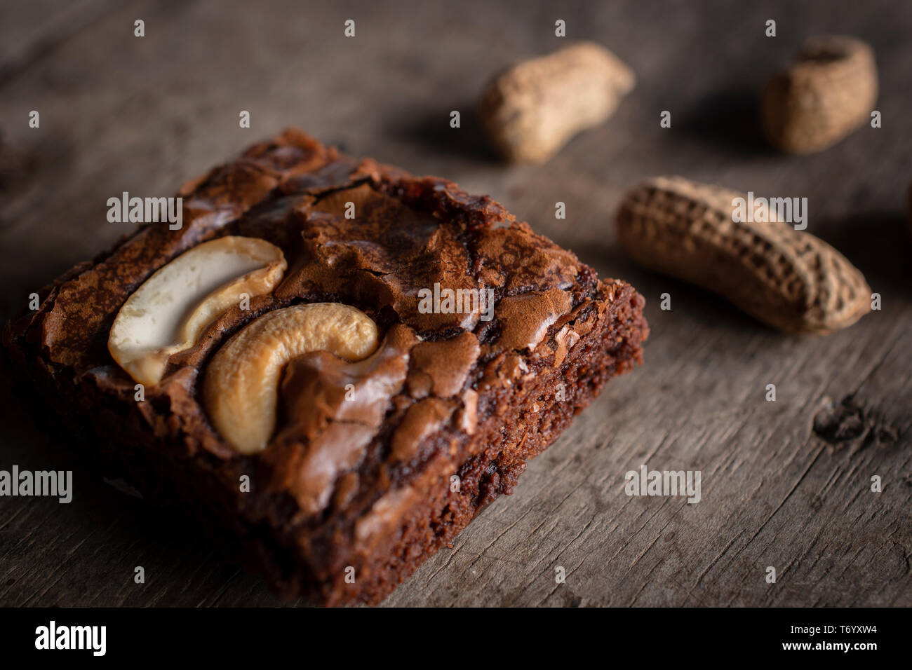 Brownie mit topping Cashewnuss und Erdnüsse auf der Rückseite. Sie setzen sich auf einem hölzernen Schreibtisch. Stockfoto