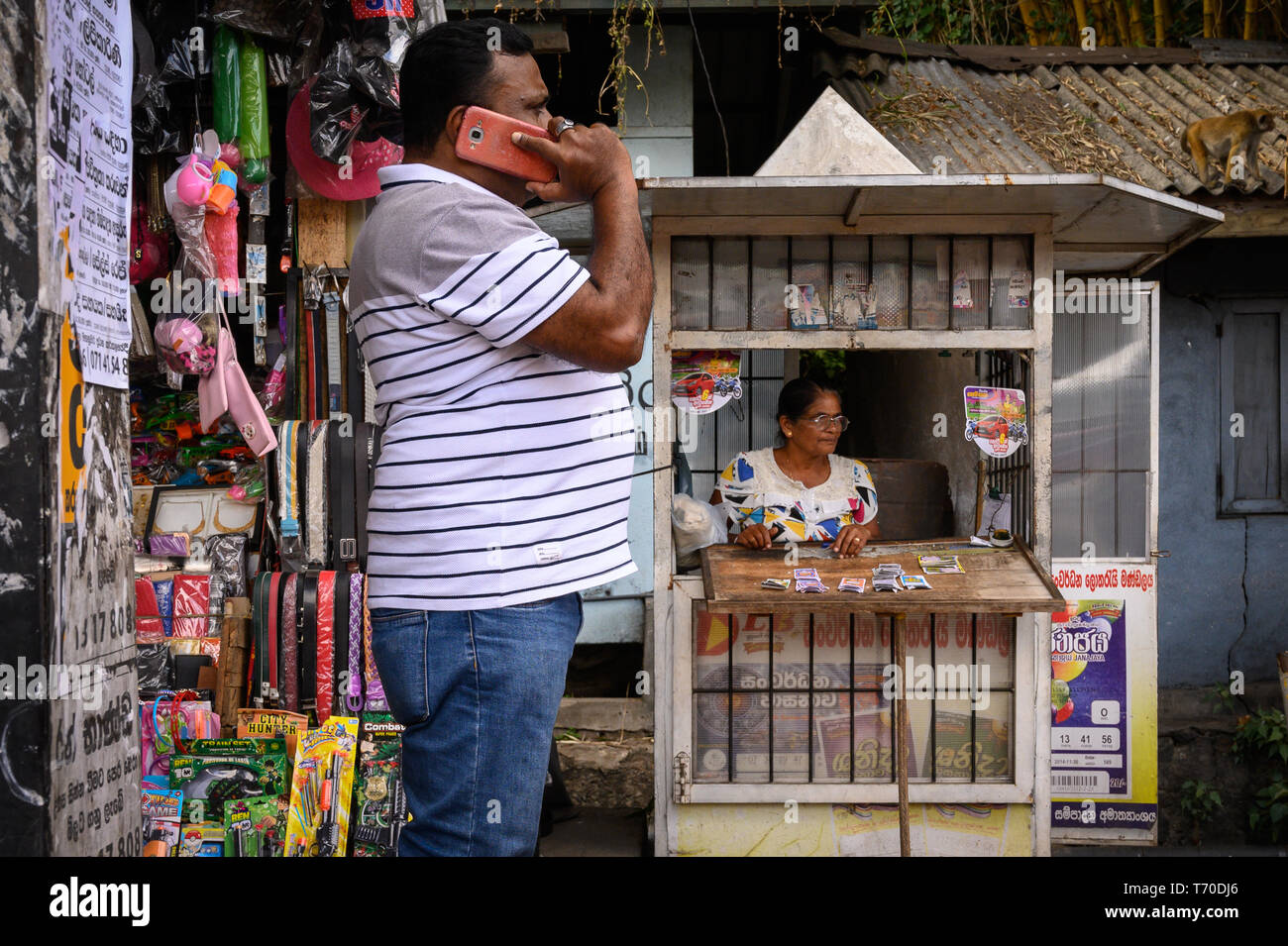 Mann einen Anruf vor einem Kiosk in Kandy, Sri Lanka Stockfoto