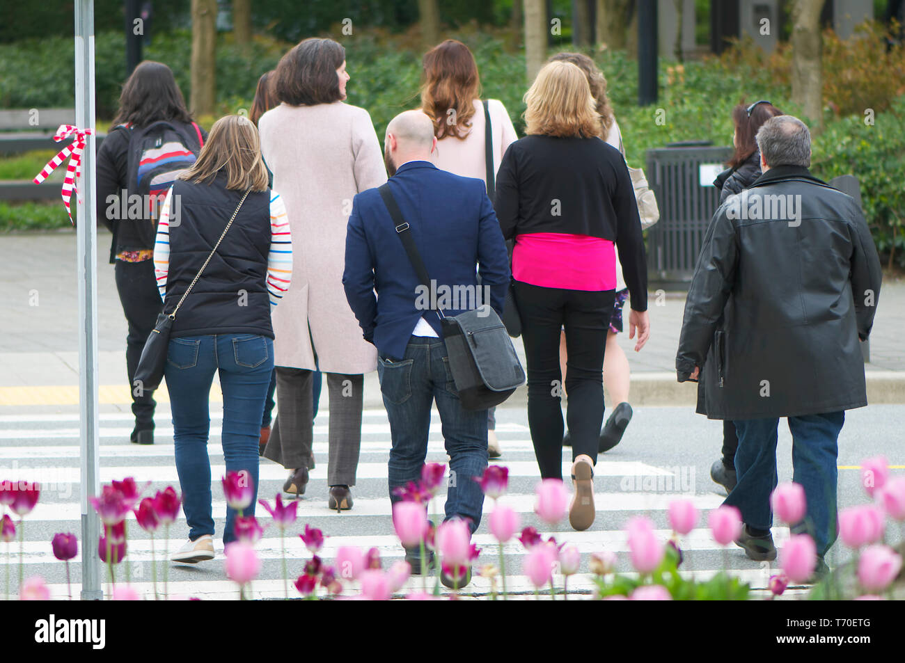 Eine Gruppe von Unterstützern für eine Meile in ihr Schuhe Kampagne für die Gleichstellung der Geschlechter eine Straße überqueren. Stockfoto
