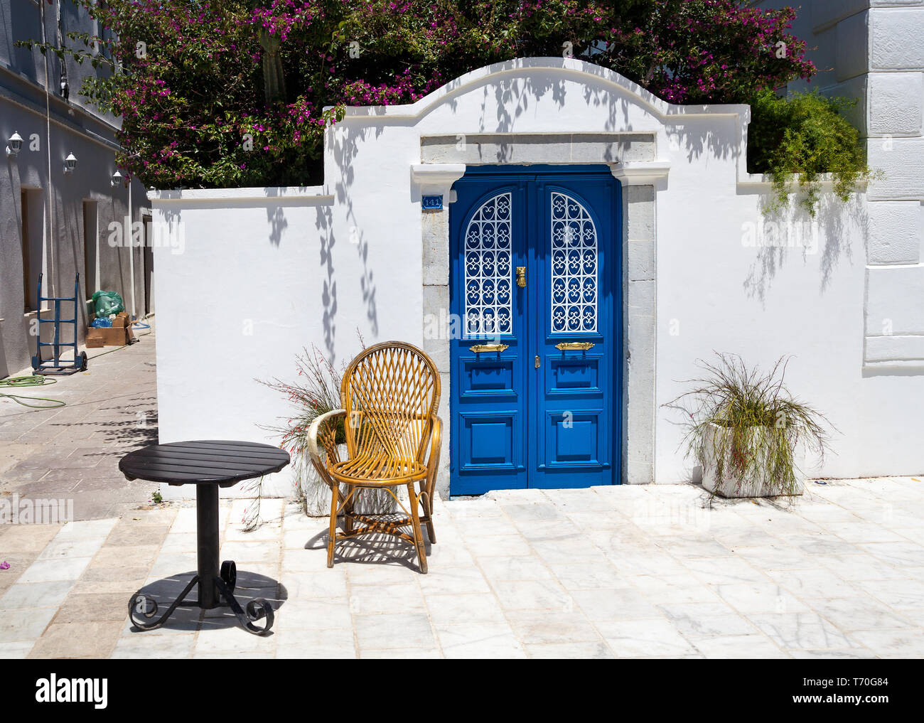 Stuhl und Tisch in der Nähe von Blue Tür an der schmalen Straße in Bodrum, Türkei Stockfoto