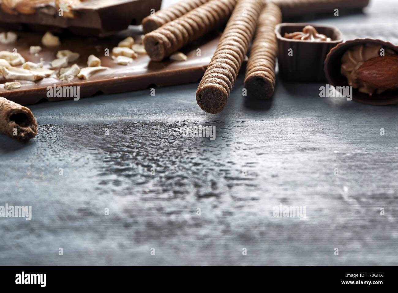 Leckere Schokolade Bonbons mit gewalzten wafer Cookies auf hölzernen Tisch Stockfoto