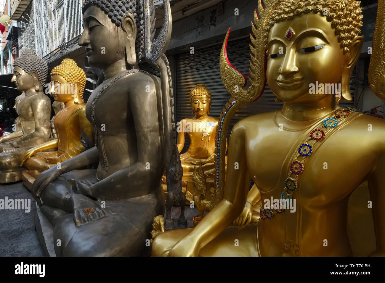 Buddha Statuen außerhalb einer Fabrik für religiöse Objekte in Bamrung Muang Road, Bangkok, Thailand Stockfoto