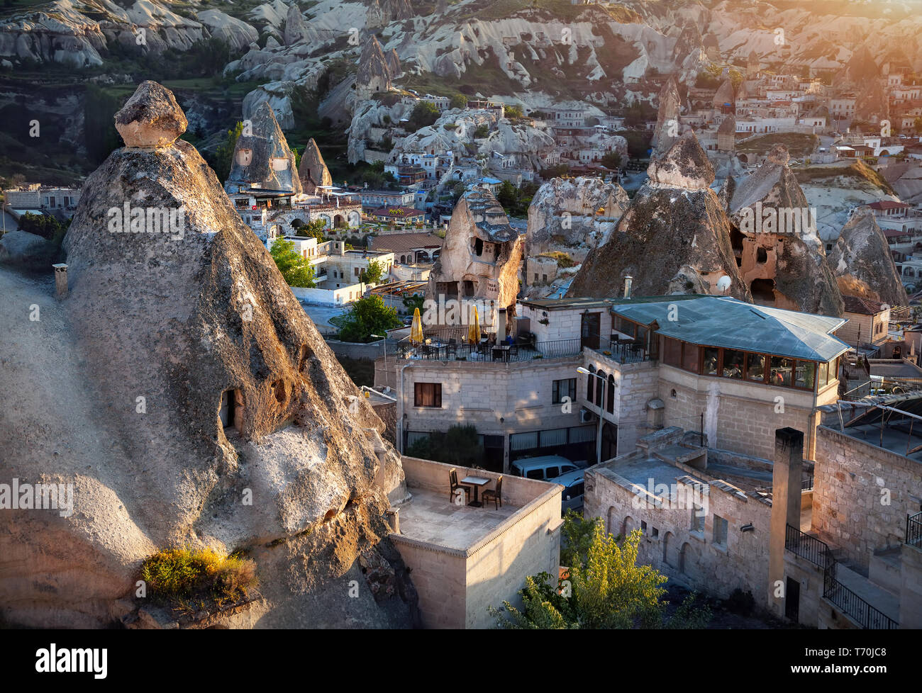 Hotels in der Tufa Berge bei Sonnenuntergang in Göreme, Kappadokien, Türkei Stockfoto