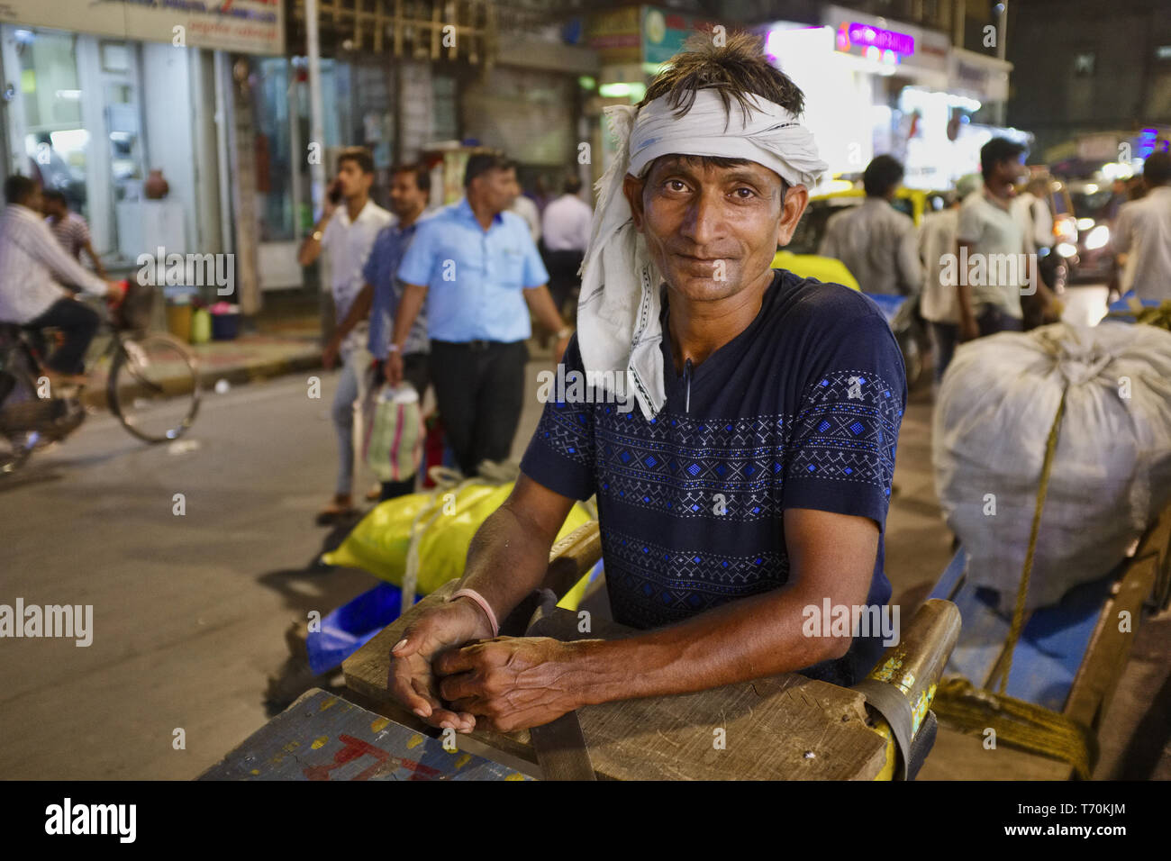 In den frühen Abend in Kalbadevi Road, Bhuleshwar. Mumbai, Indien, einen handkarren Abzieher, ein Migrant aus Nordindien, posiert für ein Foto Stockfoto