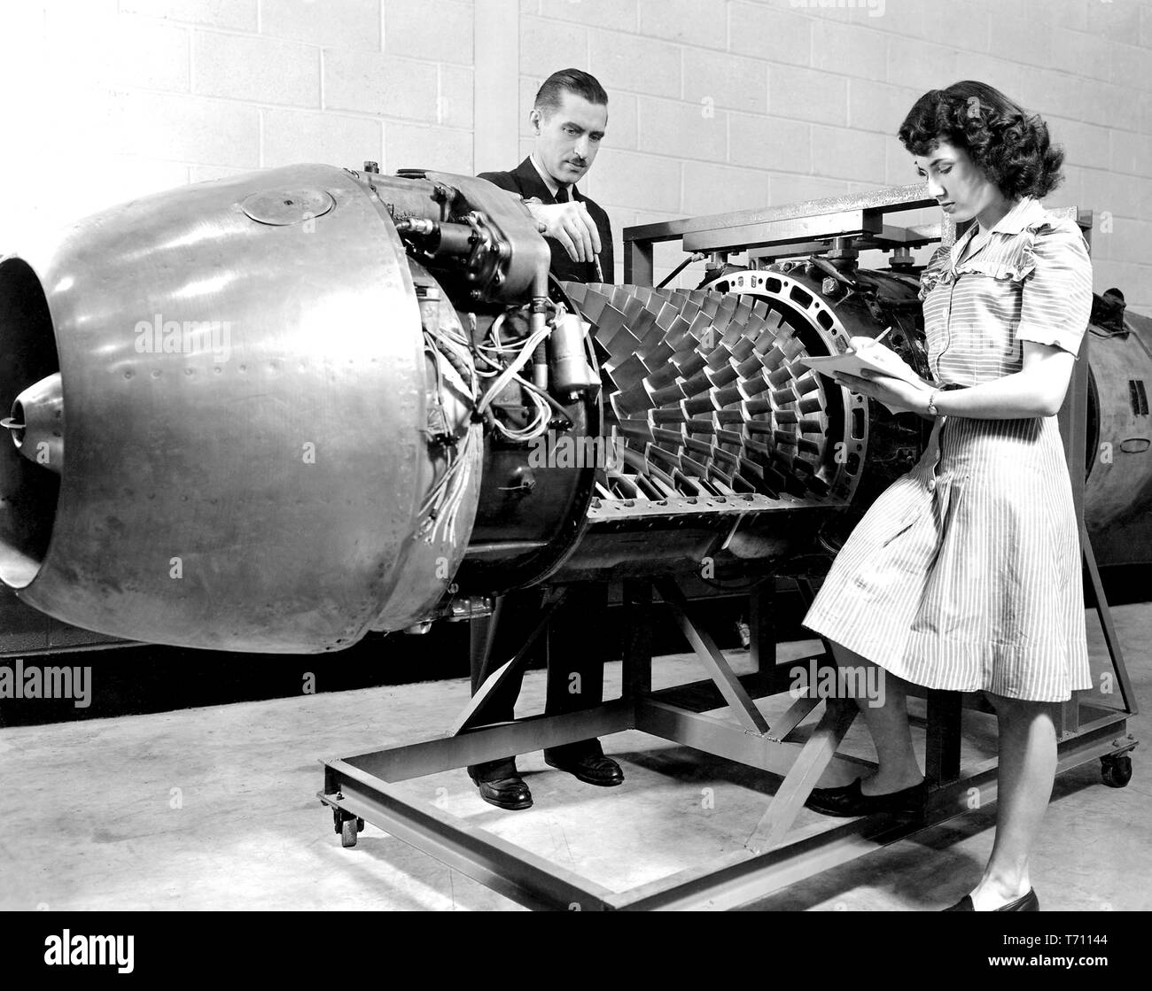 NASA-Mitarbeiter Überprüfung der JUMO 004 Jet Engine mit der Abdeckung entfernt auf der Aircraft Engine Research Laboratory des Nationalen Beratungsausschusses für die Luft- und Raumfahrt (NACA), Cleveland, Ohio, 24. März 1946. Mit freundlicher Genehmigung der Nationalen Luft- und Raumfahrtbehörde (NASA). () Stockfoto