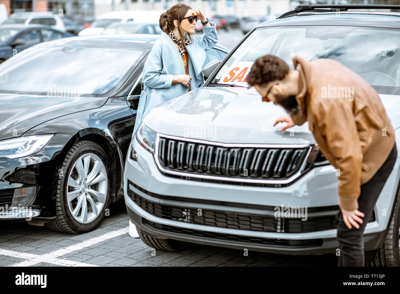 Junge elegante Paar Auswahl luxus Auto auf dem offenen Gelände des Händlers zu kaufen Stockfoto