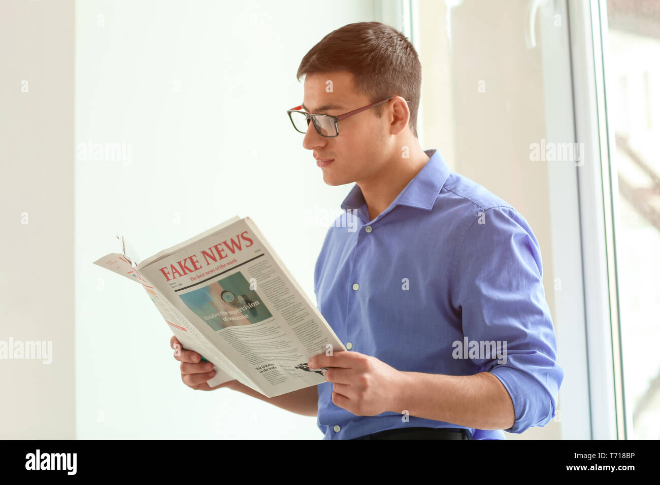 Gut aussehender Geschäftsmann lesen Zeitung im Büro Stockfoto