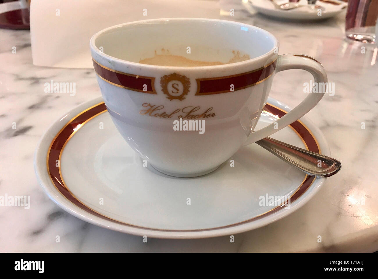 Tasse Kaffee im Cafe Sacher mit dem Schriftzug der traditionellen Hotel Sacher in Wien - Österreich. Stockfoto