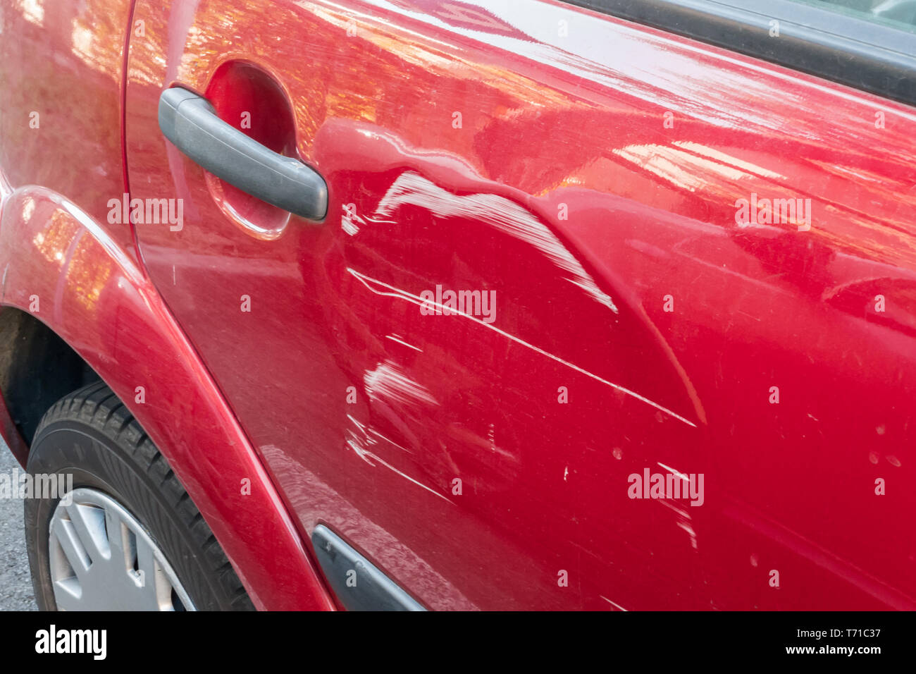 Kratzer auf der Seitentür der roten Auto. Kollision oder Unfall. Stockfoto