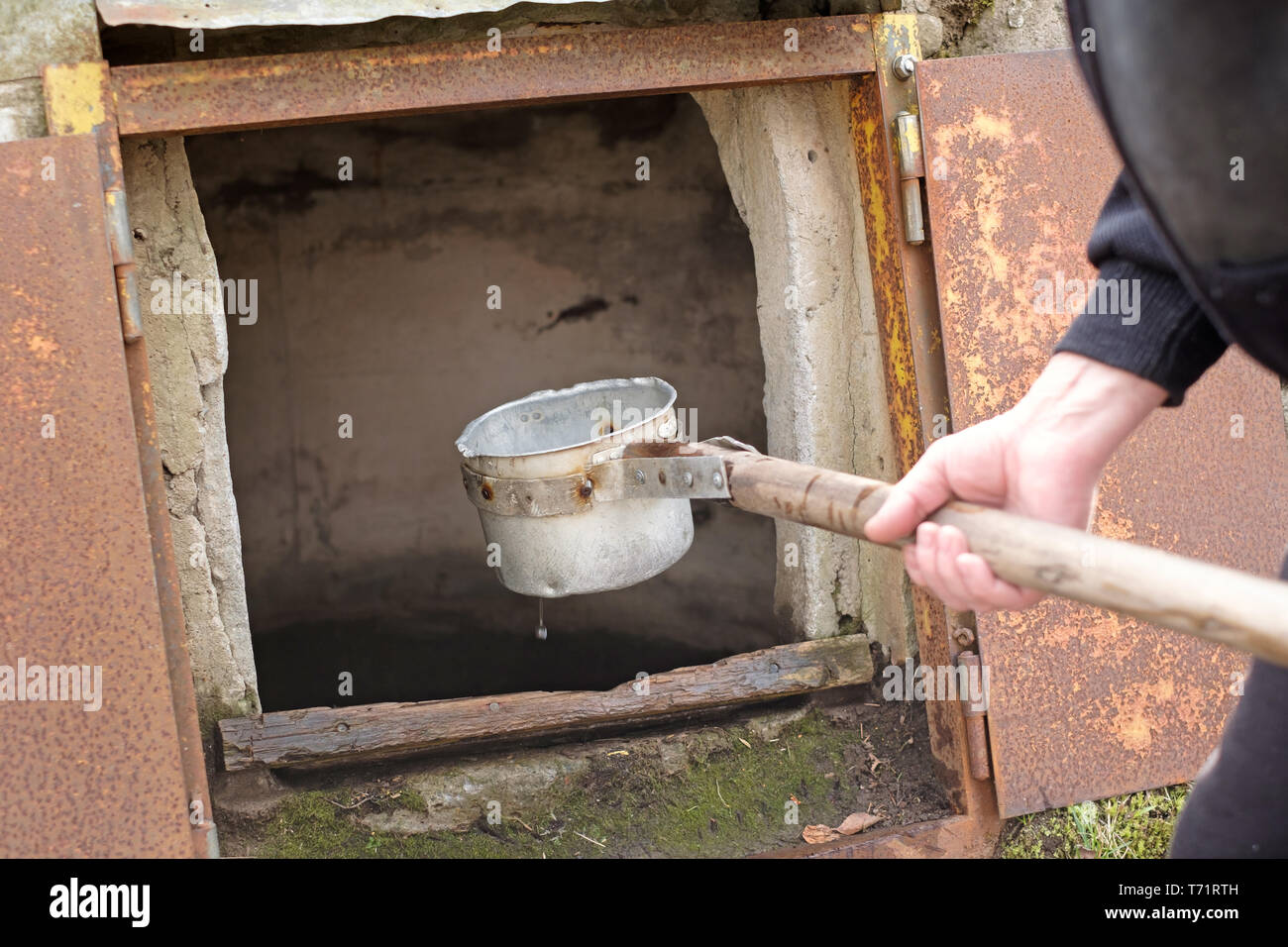 Kaukasische Mann mit Schaufel Zeichnung Wasser aus dem alten Brunnen  Stockfotografie - Alamy