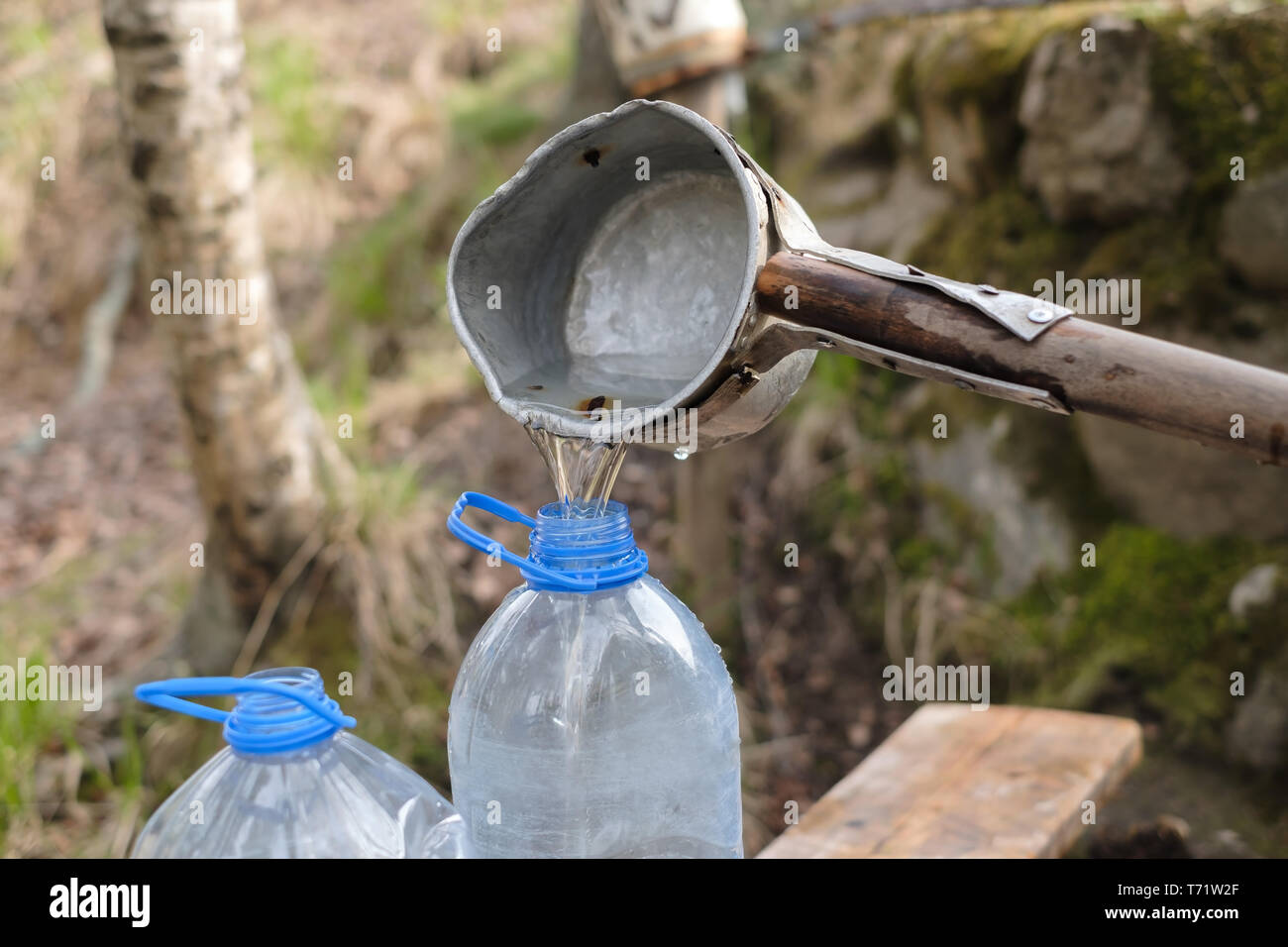 Kaukasische Mann mit Schaufel Zeichnung Wasser aus dem alten Brunnen Stockfoto