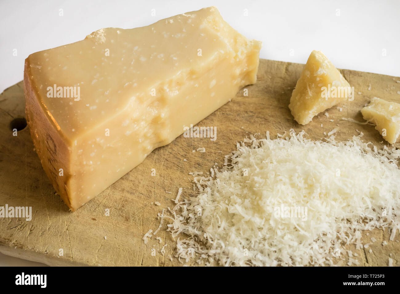 Geriebenen Parmesan auf weißem Hintergrund auf einem Holzbrett, italienisches Essen. Stockfoto