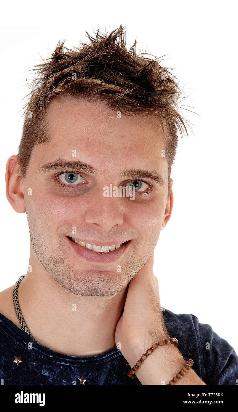 Lächelnden jungen Mann, der mit der Hand auf den Hals Stockfoto