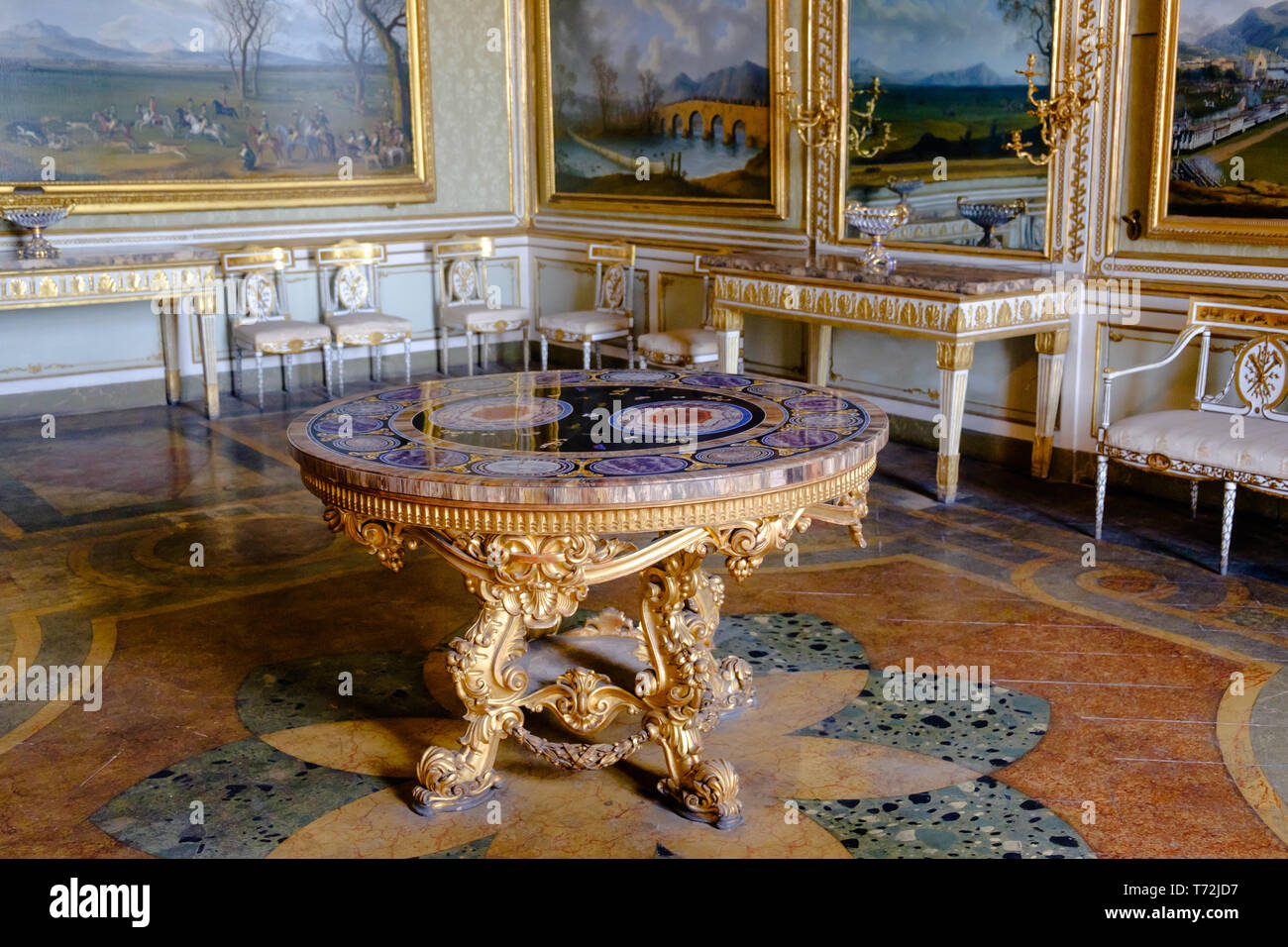 Eine neo-barocken Tabelle mit einem harten Stein table-top steht in einem königlichen Appartements der "Reggia di Caserta'. Bilder und Möbel komplett den Reichtum. Stockfoto