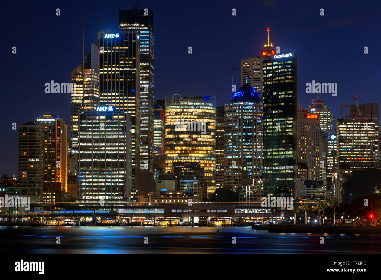 Architektur. Erste Zeile von Gebäuden in der Stadt Sydney CBD bei Sonnenuntergang. Beleuchtete Bogen der Brücke reflektieren, fliessend Wasser Sydney, New South Wale Stockfoto