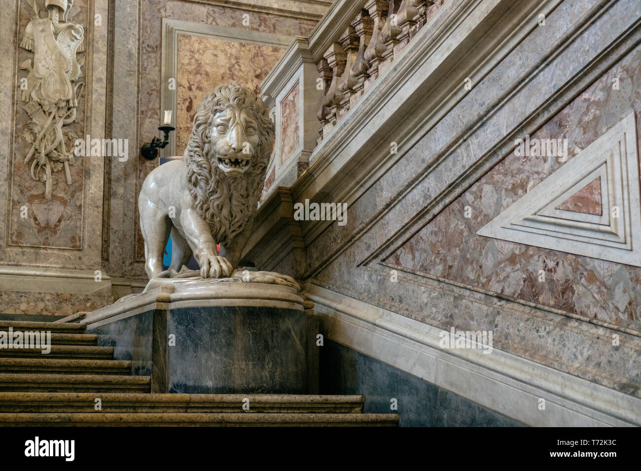 Eine majestätische Löwen aus Marmor steht an der großen Treppe der "Reggia di Caserta'. Die Treppe wurde ein Vorbild für andere königlichen Residenzen. Stockfoto