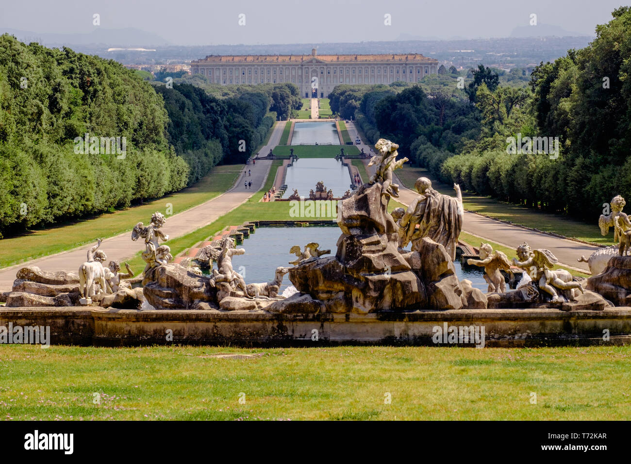 Die "Reggia di Caserta', im Hintergrund, ist eine ehemalige Königspalast. Der riesige Garten ist 3 km lang und hat Skulpturen und Kanäle. Stockfoto