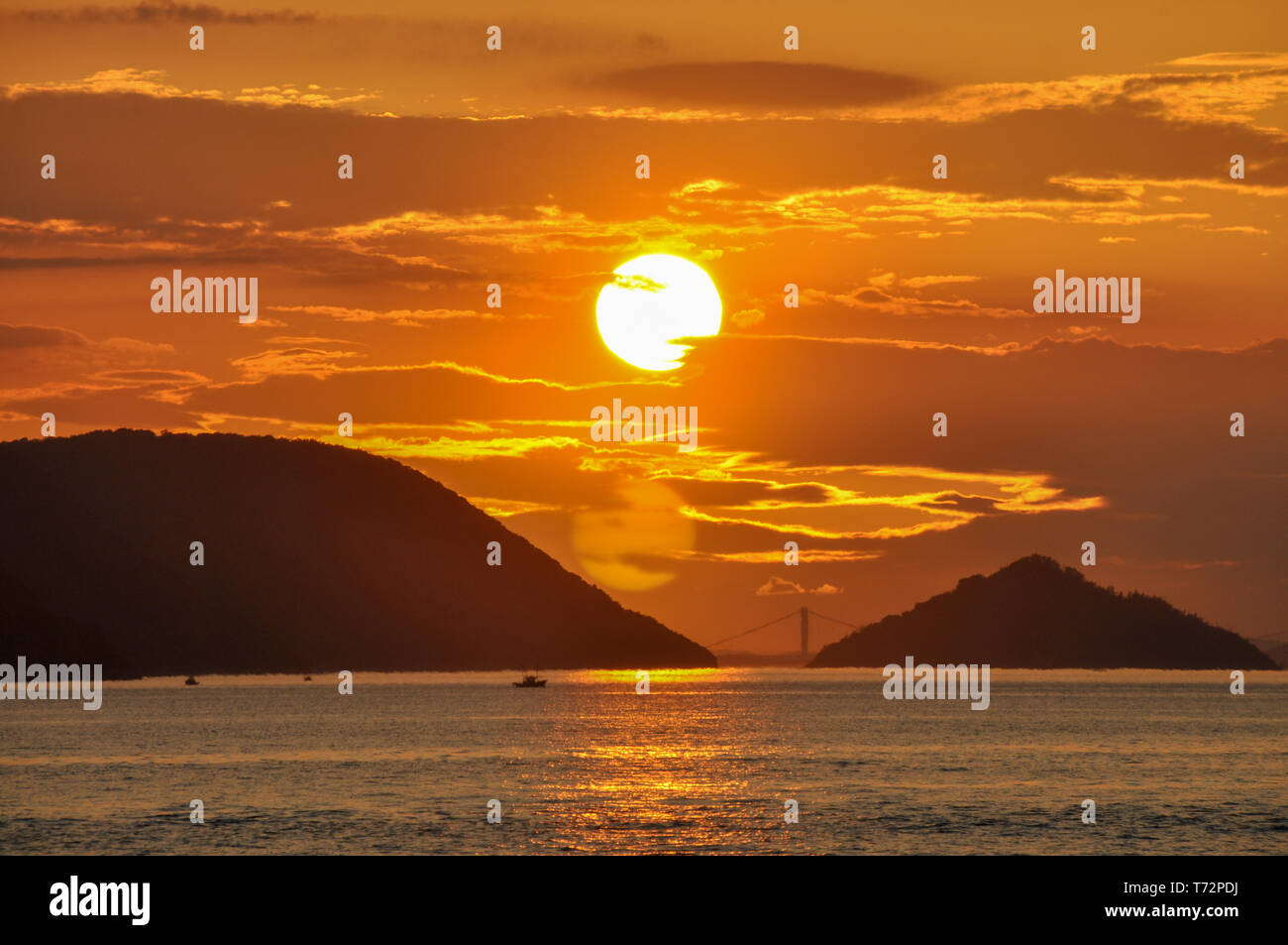 Landschaft Bild von roten und goldenen Sonnenuntergang mit Blick auf das Meer und die Insel in Takamatsu, Japan. Stockfoto