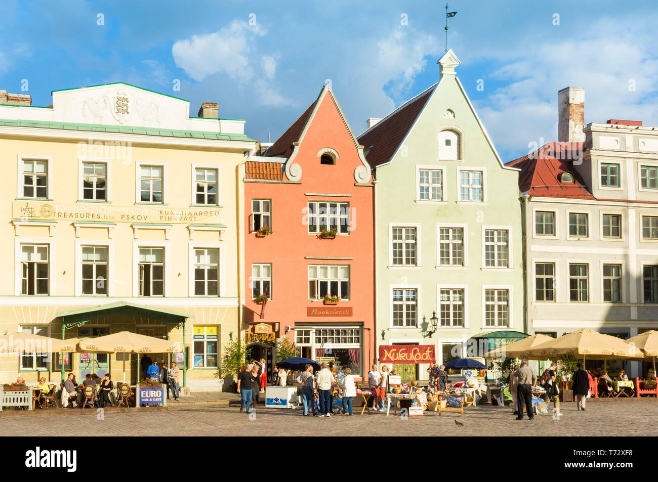 Menschen in Cafés mit Sonnenschirmen in der mittelalterlichen gepflasterten Marktplatz der Altstadt Raekoja Plats Tallinn Estland Baltikum Stockfoto