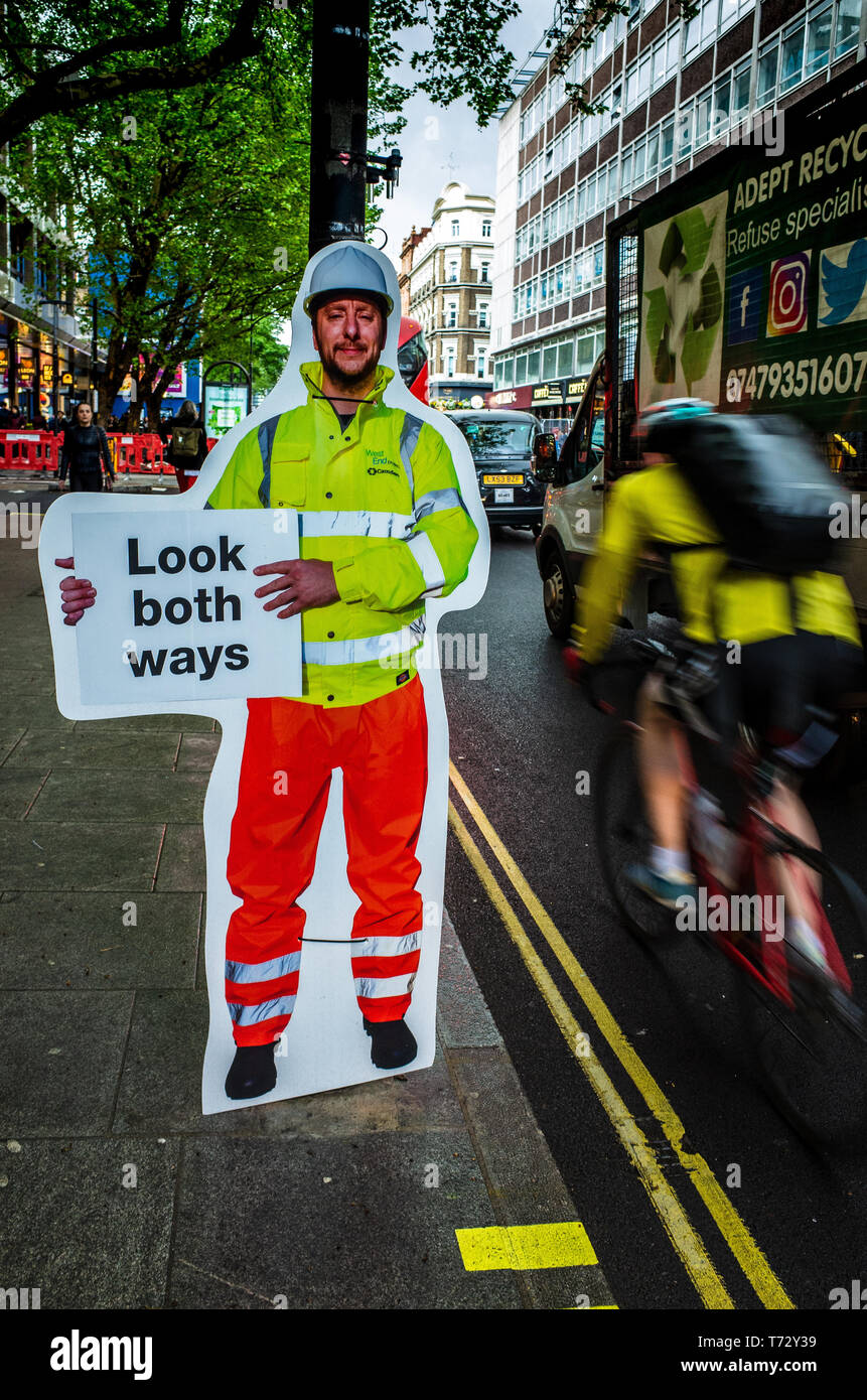 Sicherheit im Straßenverkehr unterzeichnet - ungewöhnliche Zeichen, Fußgänger in beide Richtungen in der Londoner Tottenham Court Road zu suchen, da es Änderungen von einem Weg zu zwei Art und Weise, wie der Verkehr. Stockfoto
